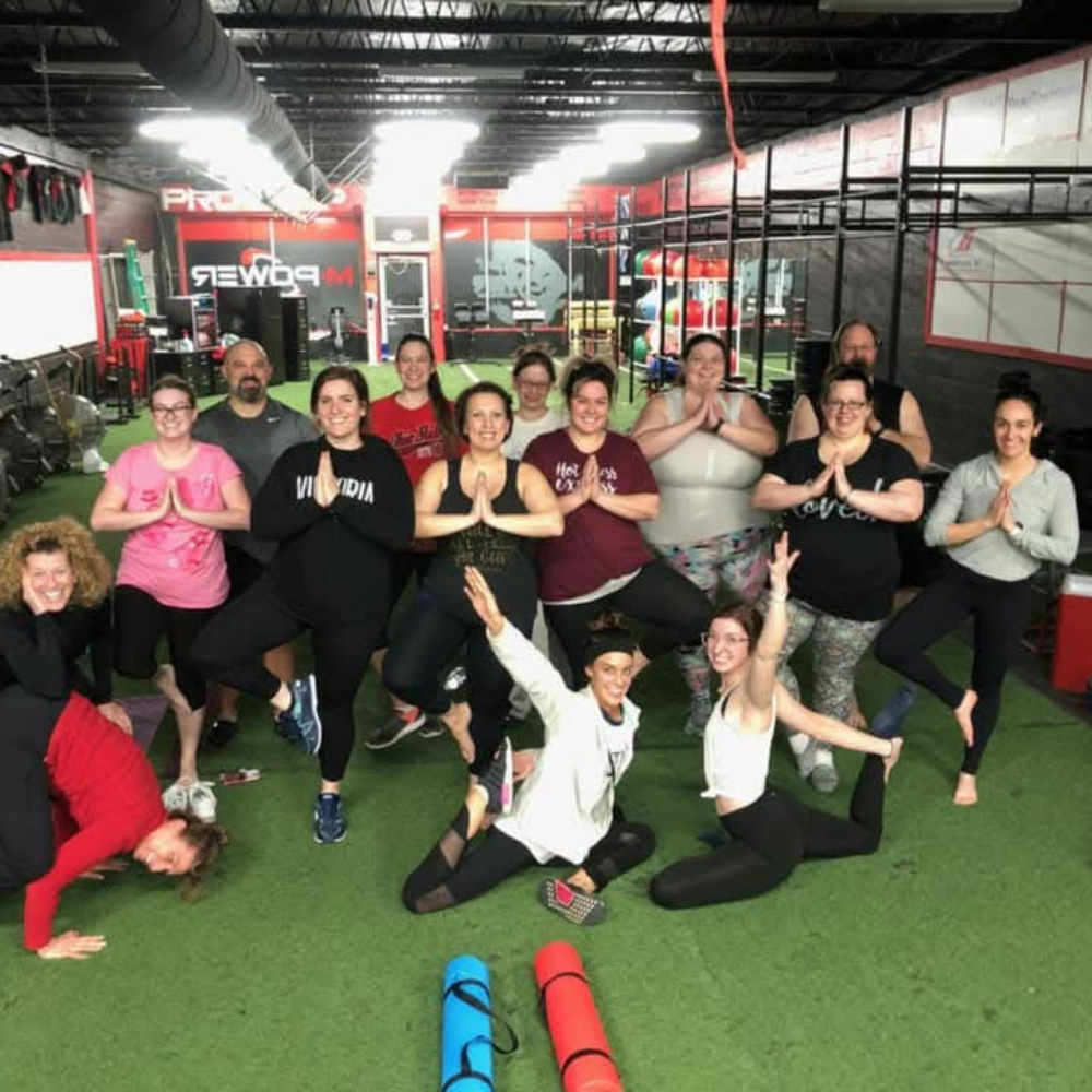 A yoga class group photo at MPower Gym & Academy in Vandalia, Ohio, fourteen members standing in tree pose