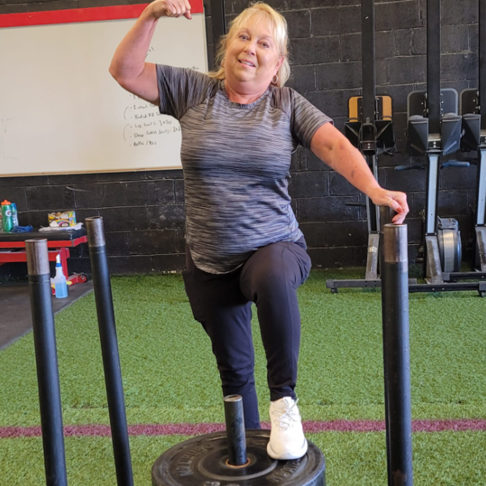 A member stepping onto a weighted sled during a strength training session at MPower Gym in Vandalia, Ohio