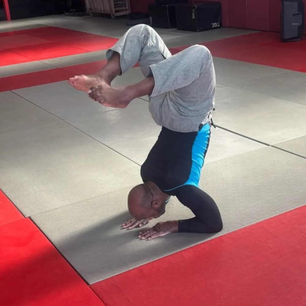 A member holding a forearm stand during mobility work at MPower Gym