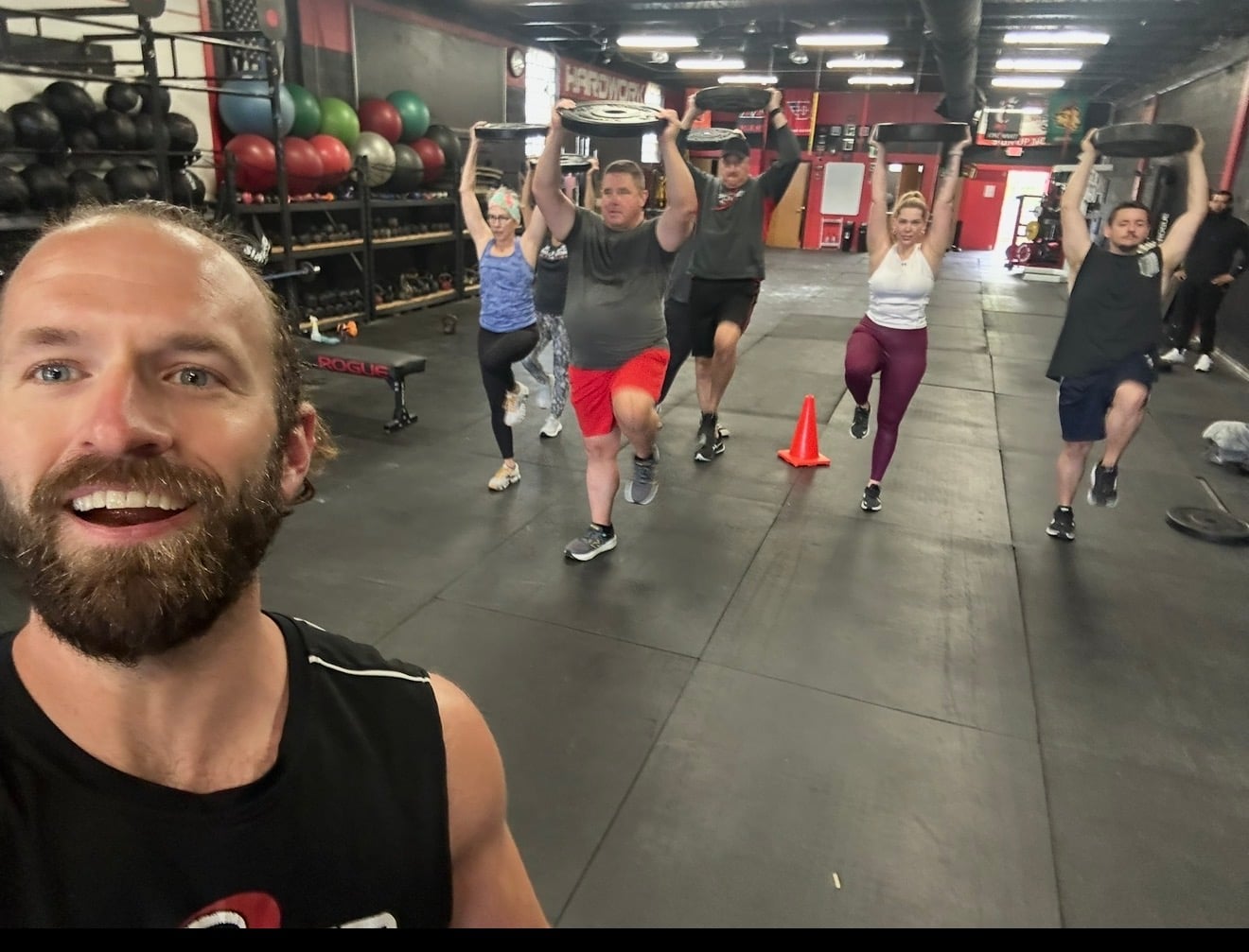A group training weighted lunges together during a strength and conditioning session at MPower Gym & Academy in Vandalia, Ohio